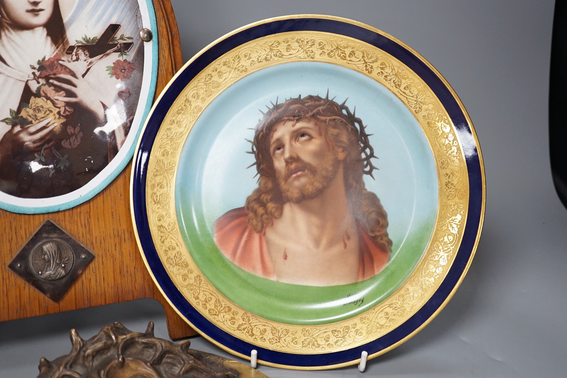A Limoges plate and cast bronze portrait of Christ with crown of thorns and a framed plaque of the Madonna, frame 37 cms high